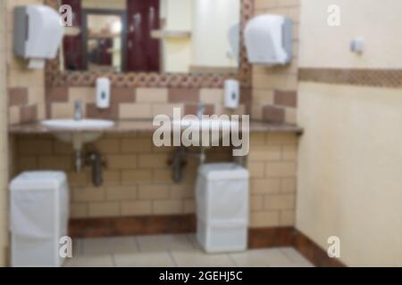 Sfondo sfocato di un piano generale di una toilette con lavandini e specchi in un ristorante o centro affari. Norme igieniche di un pubblico in Foto Stock