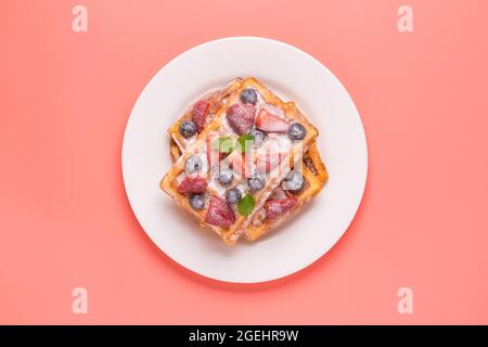 Waffle belgi con fragole, mirtilli e sciroppo, sana colazione fatta in casa, vista dall'alto Foto Stock