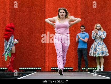 Edimburgo, Scozia, Regno Unito, 20 agosto 2021. Edinburgh International Film Festival: Una performance speciale in vista della proiezione in anteprima al Festival Theatre del film musicale amazzonico 'Everybody's Talking about Jamie' . Nella foto: Gli artisti di trascinamento scelgono i membri del pubblico per puntarsi sulla passerella, qui una giovane donna Foto Stock