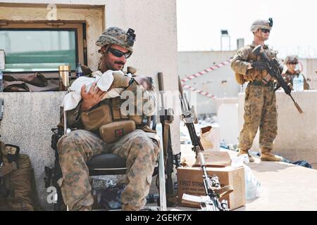 Kabul, Afghanistan. 20 ago 2021. Un marines degli Stati Uniti assegnato alla 24a unità di spedizione marina, conforta un bambino durante l'evacuazione dei non-combattenti all'Aeroporto Internazionale Hamid Karzai, parte dell'operazione Allees Refuge 20 agosto 2021 a Kabul, Afghanistan. Credit: Planetpix/Alamy Live News Foto Stock