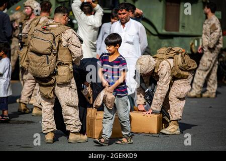 Kabul, Afghanistan. 19 ago 2021. I Marines degli Stati Uniti assegnati a Special Purpose Marine Air Ground Task Force Crisis Response, trasmettono cibo agli evacuati, durante l'evacuazione dei non combattenti all'Aeroporto Internazionale Hamid Karzai, parte dell'operazione Allees Refuge 20 agosto 2021 a Kabul, Afghanistan. Credit: Planetpix/Alamy Live News Foto Stock