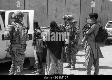 Soldati statunitensi assegnati alla terza Brigata, la decima Divisione montagna scorta gli evacuati al terminal per il check-in durante un'evacuazione all'Aeroporto Internazionale Hamid Karzai, Kabul, Afghanistan, 20 agosto. I membri del servizio degli Stati Uniti stanno assistendo il Dipartimento di Stato con un prelievo ordinato di personale designato in Afghanistan. (STATI UNITI Foto del corpo marino di Lance CPL. Nicholas Guevara) Foto Stock