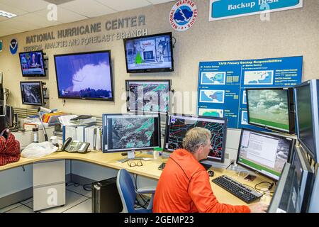 Miami Florida,National Hurricane Center NHC NOAA National Weather Service,Interior Inside forecast desk,meteorologist man maschio computer monitor Foto Stock