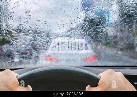 Pioggia sul parabrezza dall'interno dell'auto in ingorgo Foto Stock