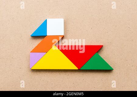 Colore tangram puzzle in anatra, swan o forma d'oca su uno sfondo di legno Foto Stock