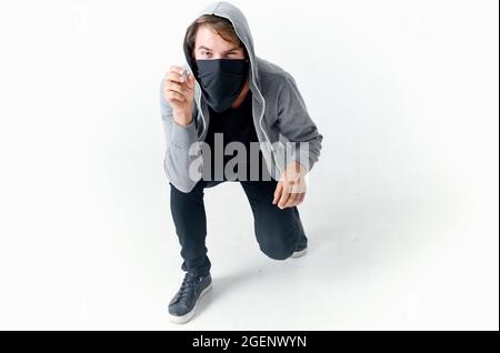 uomo che nasconde il suo volto sotto una maschera con un cappuccio anonimato crimine furto primo piano Foto Stock