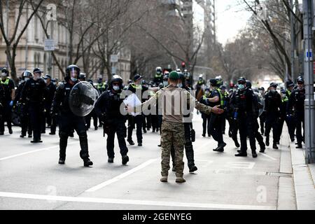 Melbourne, Australia, 21 agosto 2021. Un manifestante vestito in uniforme militare si trova di fronte alla polizia di sommosse durante la protesta della libertà il 21 agosto 2021 a Melbourne, Australia. Le proteste per la libertà si svolgono in tutto il paese in risposta alle restrizioni del governo COVID-19 e alla continua rimozione delle libertà. Credit: Michael Currie/Speed Media/Alamy Live News Foto Stock