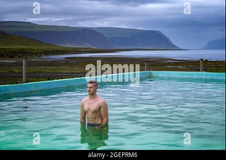 Bagni per ragazzi nella piscina riscaldata di Reykjafjardarlag, situata a Westfjords, Islanda Foto Stock