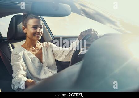 Donna che ha un auto guidare in giornata di sole Foto Stock