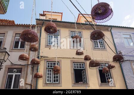 Viseu, Portogallo - 31 luglio 2021: Lampade decorative realizzate con cesti di vimini su una delle strade della città vecchia di Viseu. Foto Stock