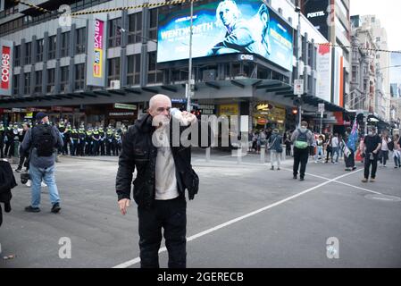 Melbourne, Australia. 21 agosto 2021. Un protester anti-lockdown tenta di alleviare il dolore di pepe spray con una bottiglia di latte. Credit: Jay Kogler/Alamy Live News Foto Stock