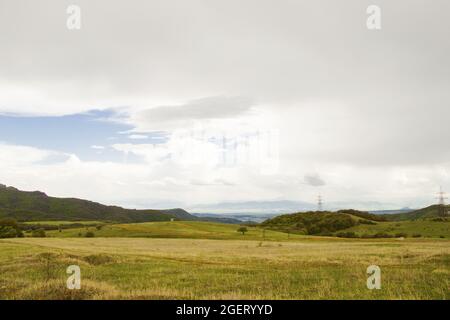 Bellissimo paesaggio di verde sotto un cielo nuvoloso in campagna Foto Stock