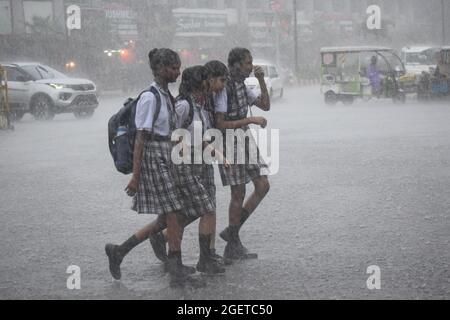 Prayagraj. 21 Agosto 2021. Le ragazze della scuola camminano su una strada in mezzo alla pioggia nel distretto di Prayagraj dello stato settentrionale dell'India di Utttar Pradesh, 21 agosto 2021. Credit: Str/Xinhua/Alamy Live News Foto Stock