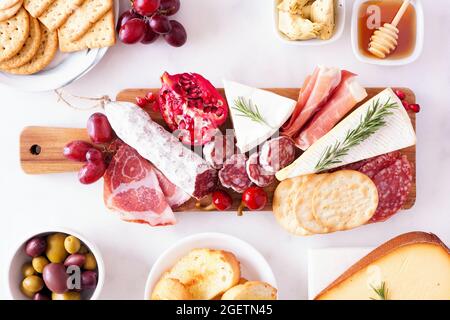 Salumi di formaggi assortiti, carni e antipasti. Vista dall'alto della scena del tavolo su sfondo di marmo bianco. Foto Stock