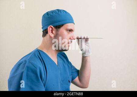 Ritratto medico giovane in abito blu con spatola in mano vicino isolato Foto Stock