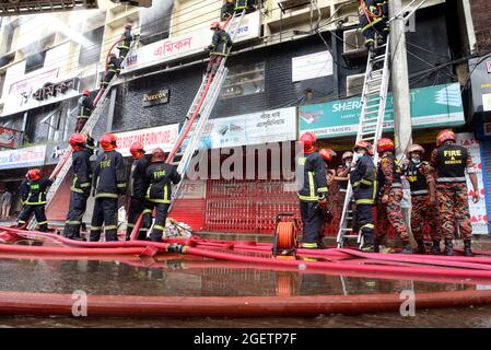 I vigili del fuoco tentano di estinguere un incendio in un edificio nella zona di Bonani a Dhaka, Bangladesh, il 21 agosto 2021. Secondo i vigili del fuoco, il fuoco nell'edificio a sei piani è scoppiato al secondo e terzo piano. Nessun incidente immediato ha detto il Servizio dei vigili del fuoco e il Dipartimento della Difesa civile. Foto Stock