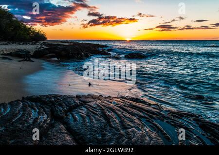 Onde che lavano sopra i flussi antichi di Lava sulla spiaggia di Kapalaoa al tramonto, Baia di Anaeho'omalu, Isola delle Hawaii, Hawaii, Stati Uniti Foto Stock