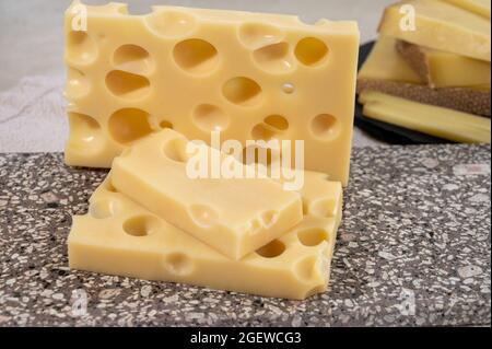 Raccolta di formaggi, emmentaler di formaggio francese semi-duro con buchi rotondi a base di latte di vacca da vicino Foto Stock