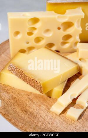 Raccolta di formaggi, formaggi francesi stagionati comte ed emmentaler con buchi rotondi a base di latte di vacca da vicino Foto Stock