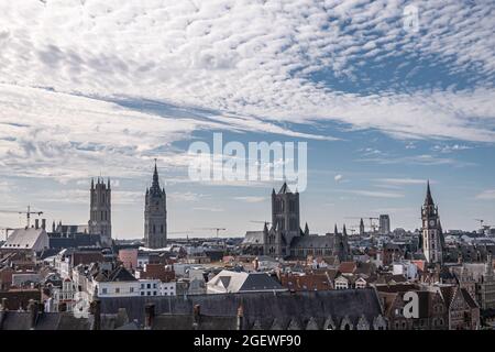 Gent, Fiandre, Belgio - 30 luglio 2021: Vista aerea sulle torri medievali, Cattedrale di Sint Baafs, Belfry, Chiesa di Sint Niklaas, torre dell'orologio postale sotto b Foto Stock