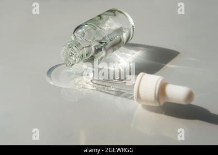 Flacone di gel di acido ialuronico con pipetta su sfondo grigio chiaro. Prodotti alla moda per l'autoproduzione. Foto Stock