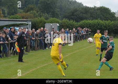 New Radnor, Powys, UK 21 agosto 2021: È il nuovo campo di calcio della Radnor Valley più pittoresco del Regno Unito ?Radnor Valley FC battere più alto classificato Llay Welfare 2-1 a casa sul loro nuovo terreno nel Trofeo FAW. Il campo è circondato dalla splendida Radnor Valley e deve essere uno dei terreni più pittoreschi del Regno Unito. Il terreno senza nome, chiamato scherzosamente il campo di pascolo (il soprannome di Radnor Valley è le capre) è a circa un miglio dal villaggio di New Radnor nel Galles centrale. Una gran parte del villaggio, la popolazione 409 si è rivelata a guardare la partita. Radnor Valley giocare nel verde, Llay Welfare in Foto Stock