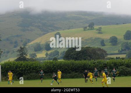 New Radnor, Powys, UK 21 agosto 2021: È il nuovo campo di calcio della Radnor Valley più pittoresco del Regno Unito ?Radnor Valley FC battere più alto classificato Llay Welfare 2-1 a casa sul loro nuovo terreno nel Trofeo FAW. Il campo è circondato dalla splendida Radnor Valley e deve essere uno dei terreni più pittoreschi del Regno Unito. Il terreno senza nome, chiamato scherzosamente il campo di pascolo (il soprannome di Radnor Valley è le capre) è a circa un miglio dal villaggio di New Radnor nel Galles centrale. Una gran parte del villaggio, la popolazione 409 si è rivelata a guardare la partita. Radnor Valley giocare nel verde, Llay Welfare in Foto Stock