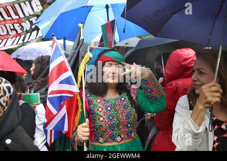 Londra, Regno Unito. 21 Agosto 2021. Un dimostratore che detiene bandiere sia afghane che britanniche come manifestanti si riunisce per dimostrare il loro sostegno all'Afghanistan e la loro sfiducia nei confronti dei talebani e per chiedere sanzioni al Pakistan come punizione per il loro sostegno ai talebani. Credit: SOPA Images Limited/Alamy Live News Foto Stock