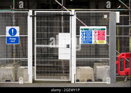 Cancello di accesso al cantiere e segnaletica per le norme sulla salute e la sicurezza Foto Stock