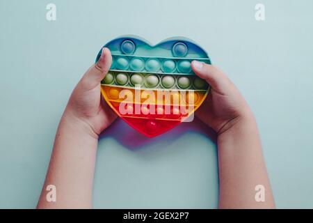 Vista dall'alto pop it fidget giocattolo antistress nelle mani dei bambini Foto Stock