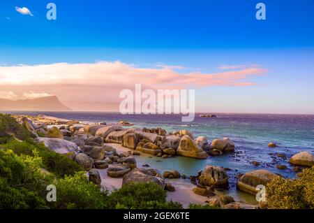 Boulders è una spiaggia turqoise rocciosa e riparata in sud Africa città del capo preso come tramonto Foto Stock