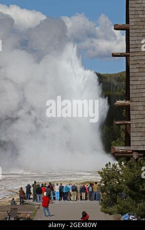 Un gruppo di persone guarda un'eruzione di Geyser Old Faithful di fronte a Old Faithful Inn.Visitors vedere Geyser Old Faithful come visto dalla Locanda Old Faithful; Data: 19 giugno 2012 Foto Stock