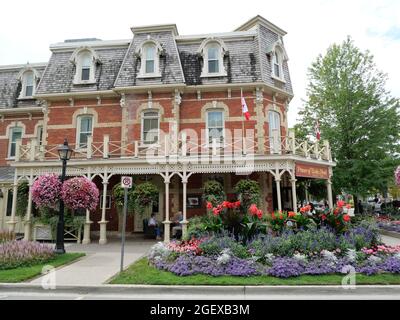 Vecchio hotel vittoriano a Niagara-on-the-Lake, Ontario, con colorate decorazioni floreali sulla strada in estate. Foto Stock