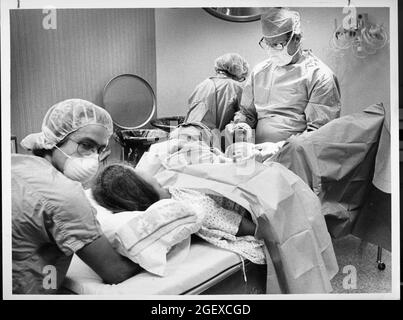 Austin Texas USA, 1982: Storia del parto che ha funzionato nell'americano-statesman di Austin in 1982..Obstetrician assiste alla nascita del bambino della donna nella stanza di parto dell'ospedale con l'assistenza dell'infermiere di parto. File 82-48 Box #12 la nascita era 6-2-1982. Foto Stock