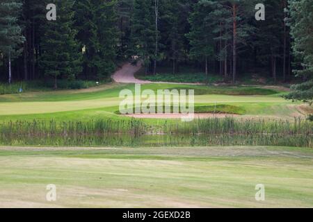 Lago circondato dal verde sul territorio del golf club. Serbatoio artificiale. Foto Stock