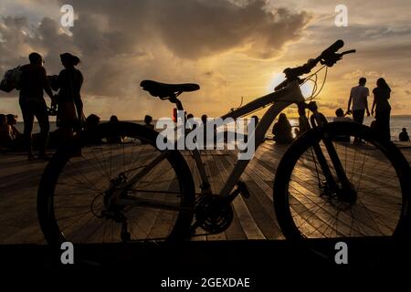 Salvador, Bahia, Brasile - 08 gennaio 2019: Silhouette di persone al molo di Porto da barra a Salvador (BA), con biciclette stazionarie. Foto Stock