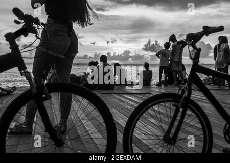 Salvador, Bahia, Brasile - 08 gennaio 2019: Silhouette di persone al molo di Porto da barra a Salvador (BA), con biciclette stazionarie. Foto Stock