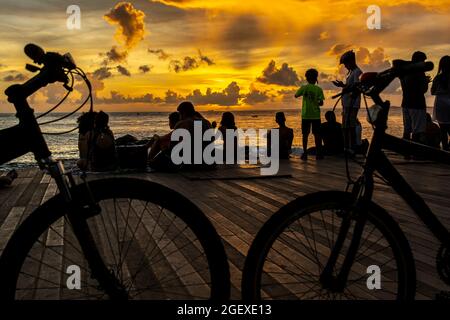 Salvador, Bahia, Brasile - 08 gennaio 2019: Silhouette di persone al molo di Porto da barra a Salvador (BA), con biciclette stazionarie. Foto Stock