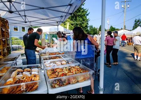 Clienti che acquistano prodotti da forno dalla panetteria artigianale Bodhi's presso il mercato agricolo di Qualicum Beach, British Columbia, Canada Foto Stock