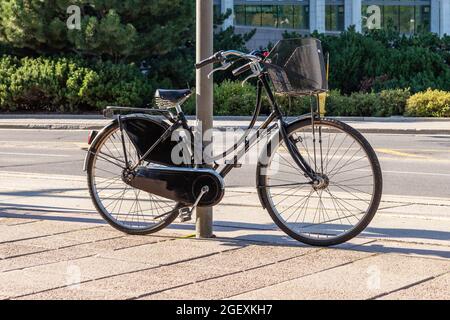 Ottawa, Canada - 2 agosto 2021: La bici parcheggiata accanto al palo, protetto con dispositivo di bloccaggio sulla strada nel centro di Ottawa, Canada. Vita sana Foto Stock