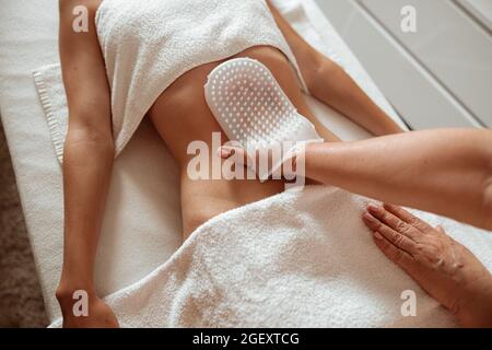 Giovane donna con massaggio professionale allo stomaco nel salone termale Foto Stock