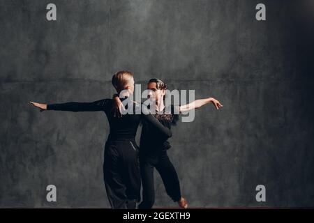 Coppia ballerini in costumi neri ballando in sala da ballo rumba dance Foto Stock