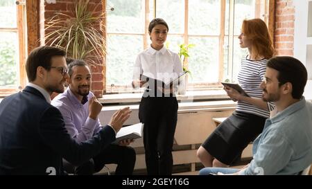 Diversi membri del personale si riuniscono durante la riunione in ufficio Foto Stock