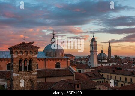 Una bella vista di vecchi edifici e chiese sotto un cielo nuvoloso al tramonto a Venezia, Italia Foto Stock