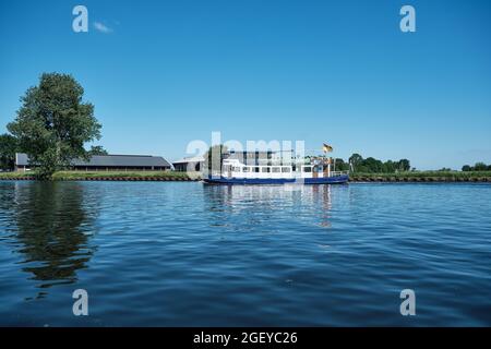 Amersfoort, Hoogland, Paesi Bassi 13 giugno 2021, Bicyboat, traghetto eemland sul fiume EEM con passeggeri e una diga e cielo blu nel Foto Stock