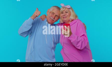 Felice uomo coppia anziano donna nonni utilizzare il telefono cellulare festeggiamento scoperto grande grande win notizie Foto Stock