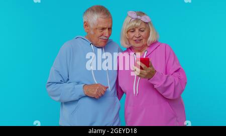 Felice uomo coppia anziano donna nonni utilizzare il telefono cellulare festeggiamento scoperto grande grande win notizie Foto Stock