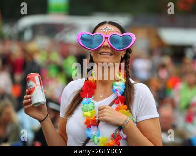 Gli spettatori erano vestiti per l'occasione nel loro colorato vestito godendo la musica dal vivo al Rewind South 80s Music Festival a Henley-on-Thames, Regno Unito Foto Stock