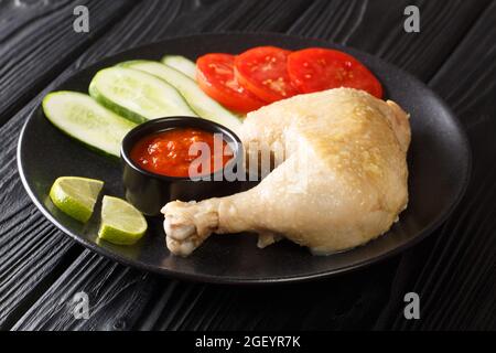 L'Ayam pop è un piatto tradizionale indonesiano preparato con una combinazione di pollo, burro, aglio, latte di cocco e primi piatti di condimenti nel piatto sul Foto Stock