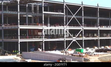 grande fondo del cantiere, struttura in cemento e acciaio di un grande e moderno edificio di magazzino in costruzione con ponteggi e travi Foto Stock